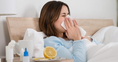 Young Woman Infected With Cold Blowing Her Nose In Handkerchief