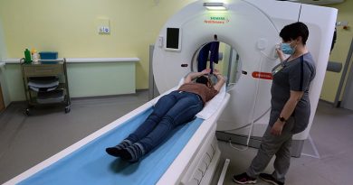Рентген-лаборант Наталья Попова помогает пациенту занять правильное положение для предстоящего КТ исследования