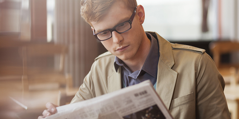 Man sitting in a restaurant and reading a newspaper