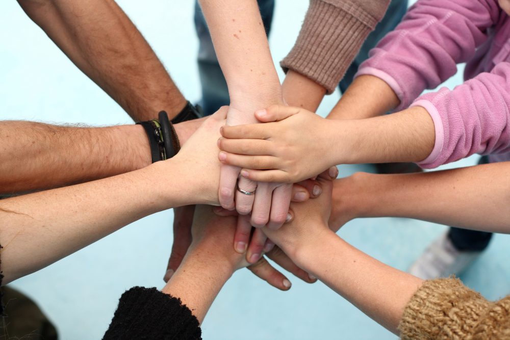 Five people join their hands together